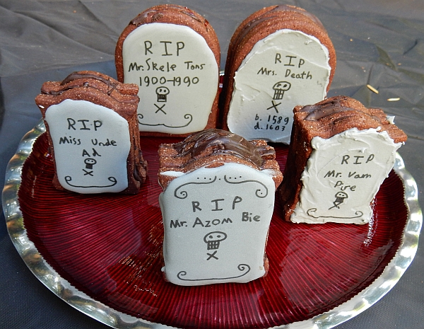 Five 3D tombstone cookies on a blood-red platter